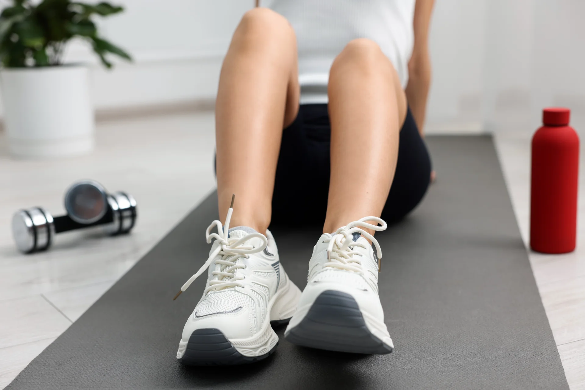 woman exercises on mat with dumbbells and water bo 2026 05 20 13 31 01 utc
